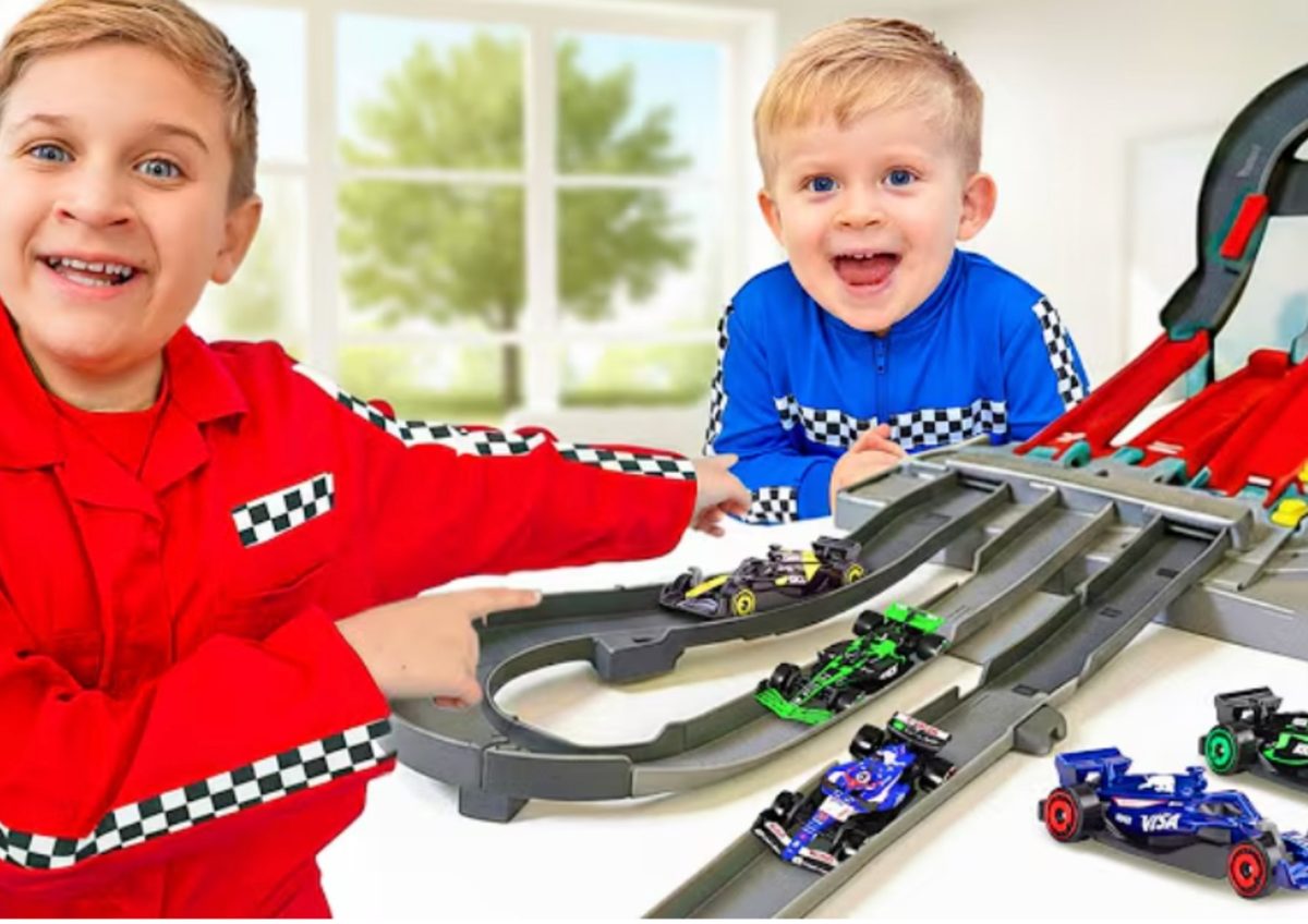 Two young creators racing Hot Wheels F1 cars on a track
