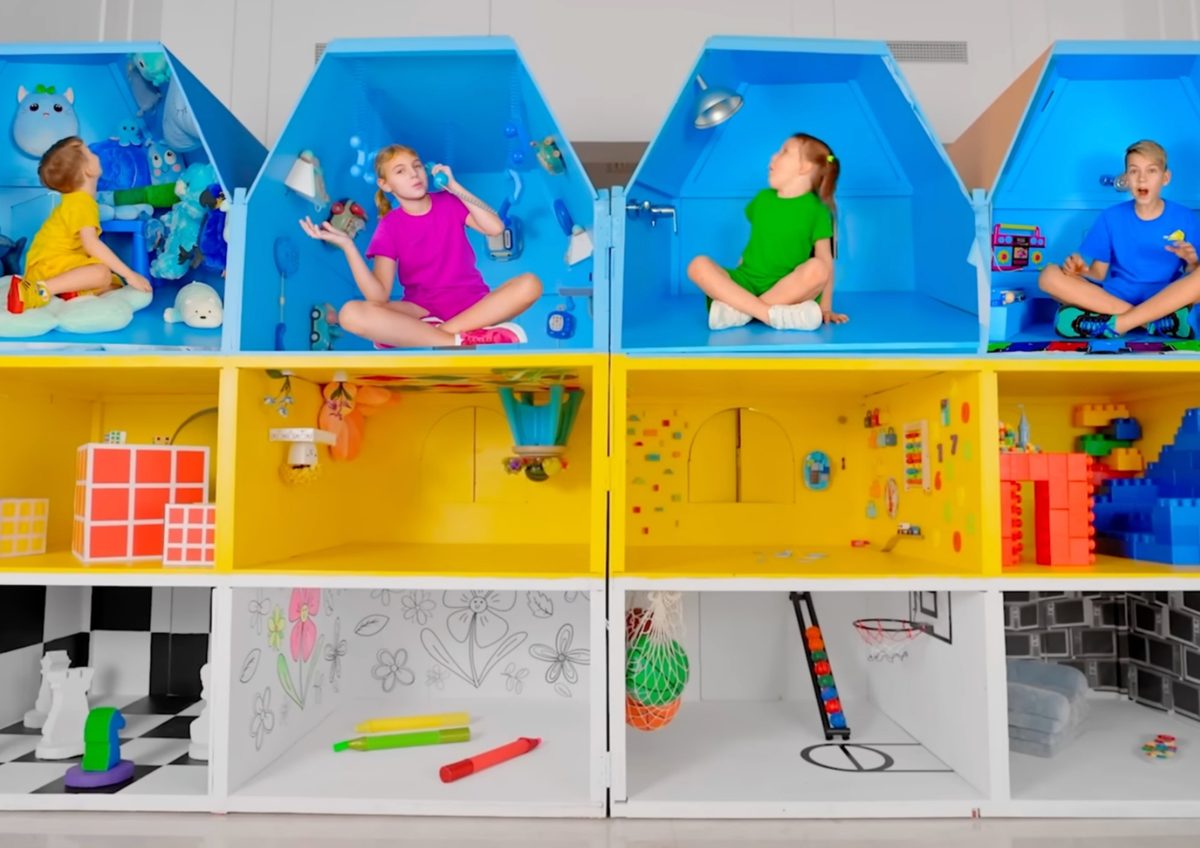 Creators playing inside a life-size colourful dollhouse